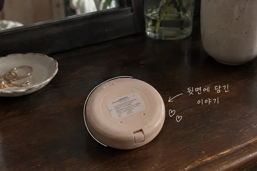 나무 화장대 위에 뒤집어 놓은 상표 없는 화장품 콤팩트와 작은 라벨, 흰 손글씨를 담은 AI 생성 이미지.