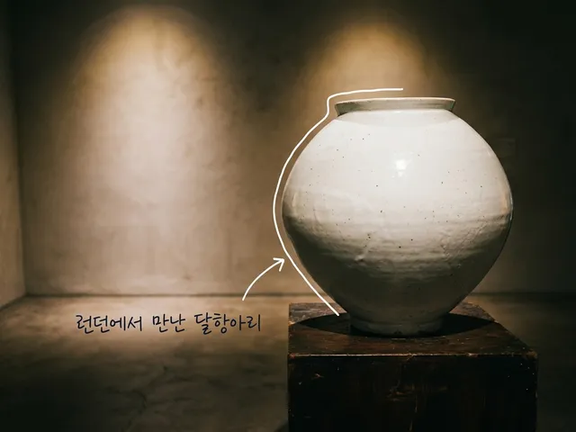 조명이 은은한 전시 공간의 낮은 받침 위에 놓인 흰 달항아리를 담은 AI 생성 이미지. 흰 선과 ‘런던에서 만난 달항아리’ 손글씨가 얹혀 있다. 실제 전시 사진이 아니다.