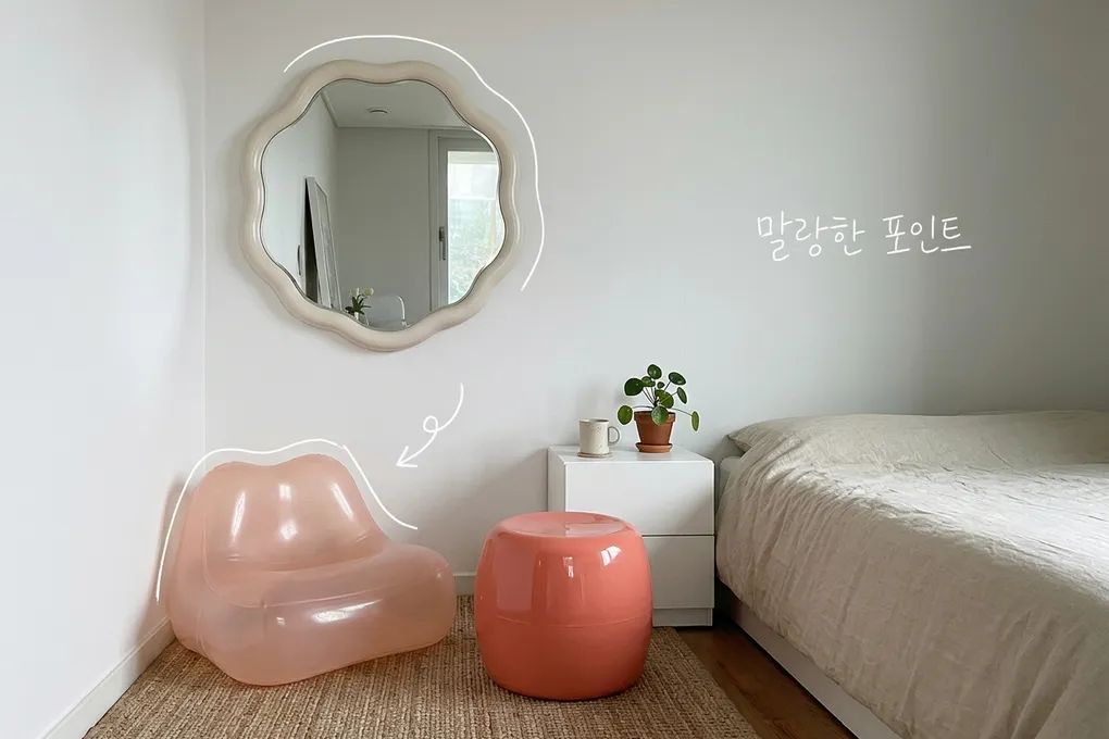 흰 벽 방 한구석에 물결 모양 거울, 반투명 분홍 의자, 코랄색 스툴이 놓인 AI 생성 이미지. 거울과 의자에 흰 선이 얹혀 있고 '말랑한 포인트' 손글씨가 있다.