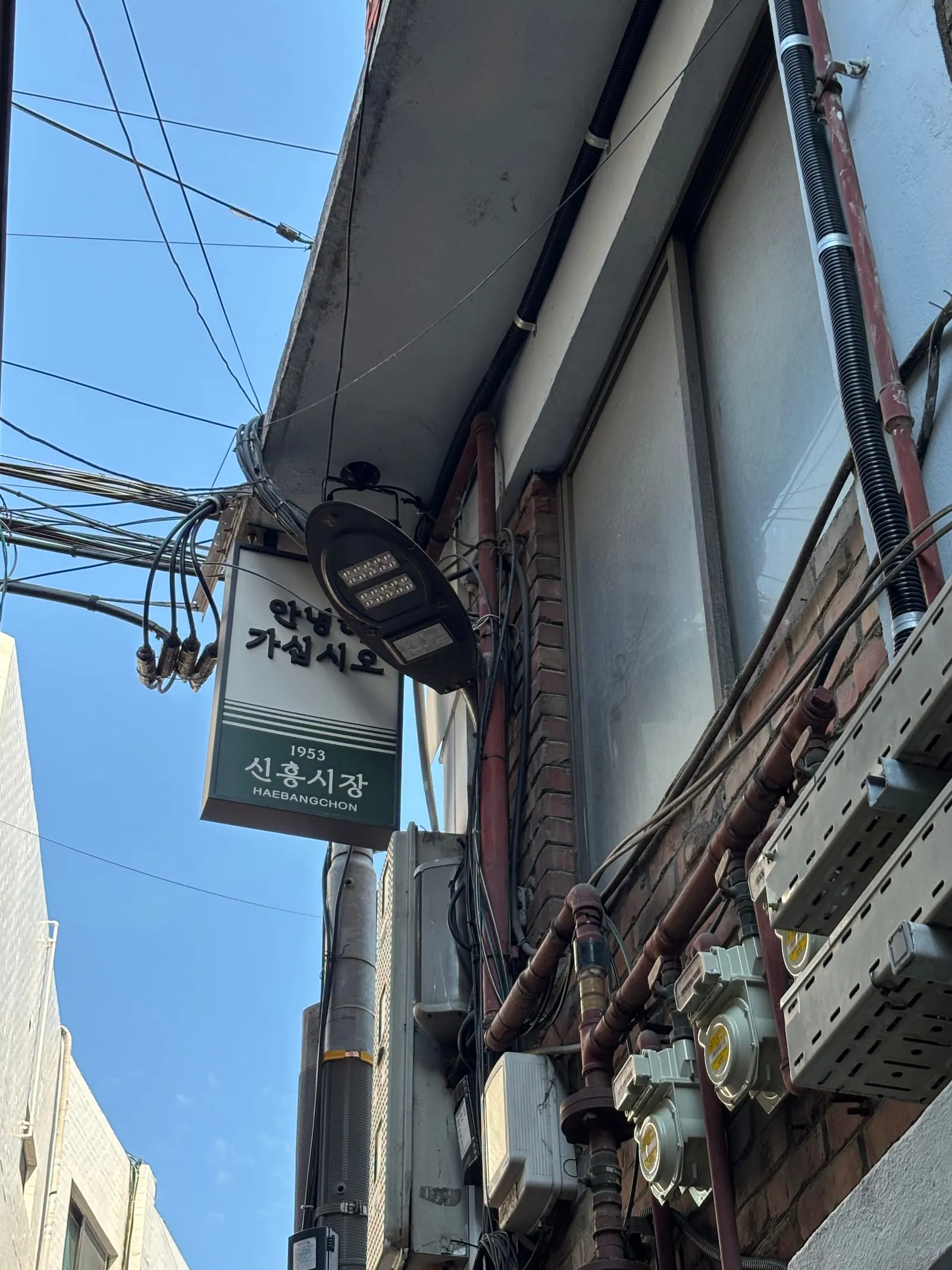 A green sign reading 'goodbye, take care, 1953 Sinheung Market Haebangchon'