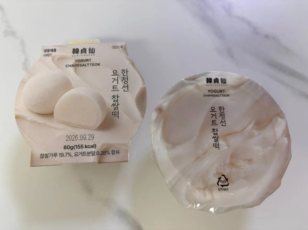 The Hanjeongseon Yogurt Mochi package. The front reads 'frozen product, sherbet,' '80 g (155 kcal)' and 'glutinous rice flour 19.7%, yogurt powder 0.28%,' with the plastic lid beside it
