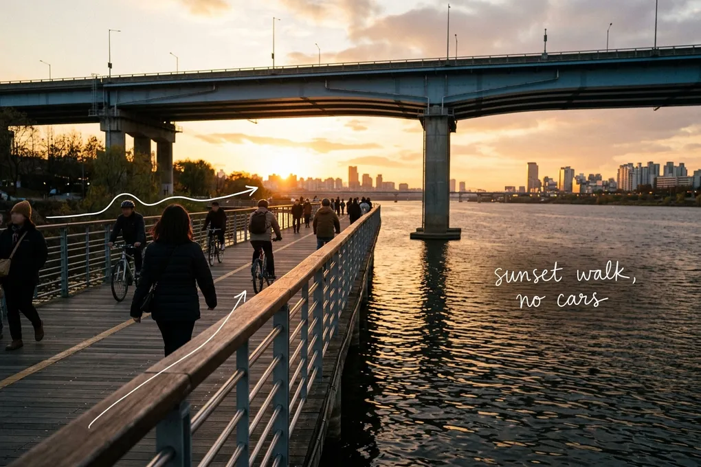 AI-generated image of people walking and cycling on a low riverside boardwalk at sunset under a higher bridge. White pen lines trace the railing and a handwritten note reads 'sunset walk, no cars'.