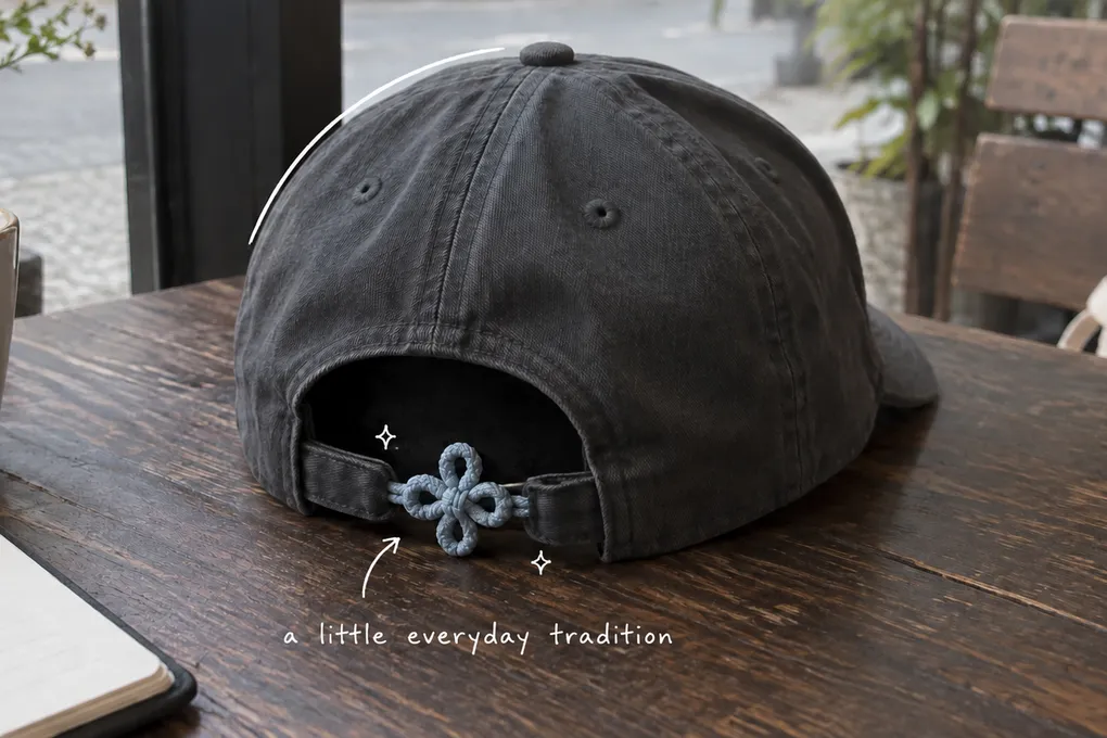 AI-generated illustration of a dark baseball cap with a decorative cord knot at the back, with a small white handwritten note.