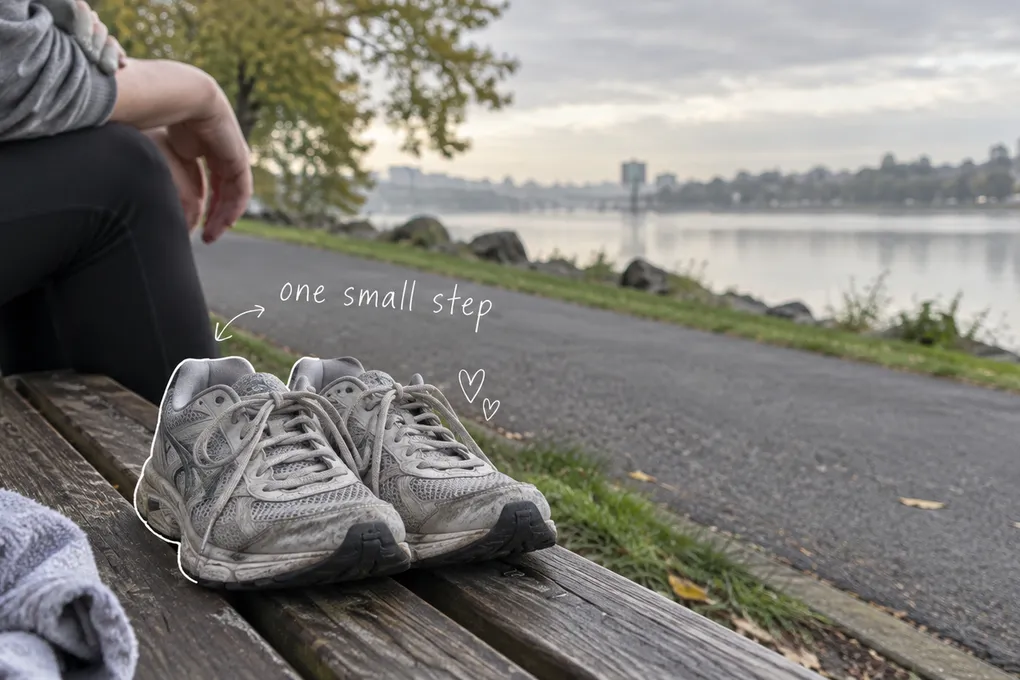 AI-generated worn running shoes on a riverside bench, with an anonymous seated figure and the handwritten words one small step.